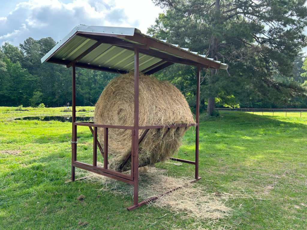 Covered round bale feeder
